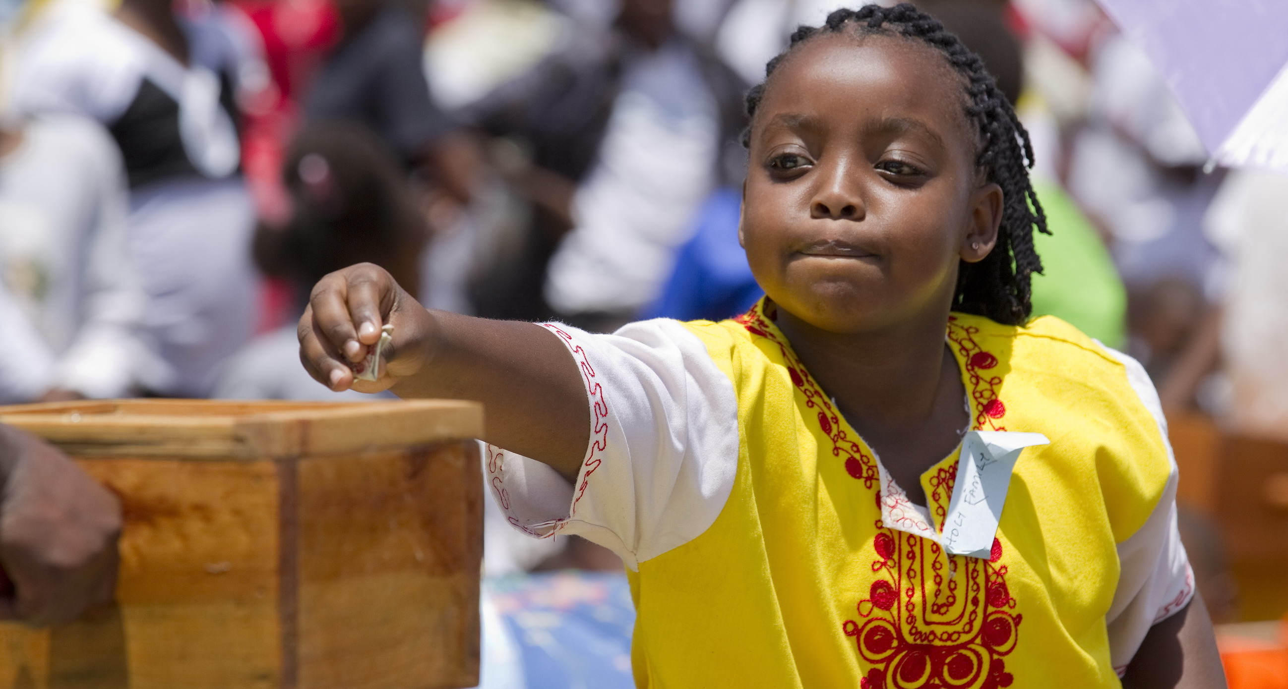 A girl makes an offering during Mass marking Missionary Childhood Day in Nairobi, Kenya, Feb. 19. Held annually by the Pontifical Missionary Childhood society, the outdoor service drew more than 30,000 children from around the Archdiocese of Nairobi. (CNS photo/Nancy Wiechec) See KENYA-CHILDREN and KENYA-PMC