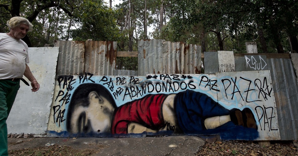 6set2015---homem-passa-por-um-grafite-que-retrata-o-menino-sirio-aylan-shenu-3-encontrado-morto-em-uma-praia-na-turquia-em-muro-na-cidade-de-soro(1)