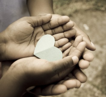 love; beautiful hands of children holding green heart shape
