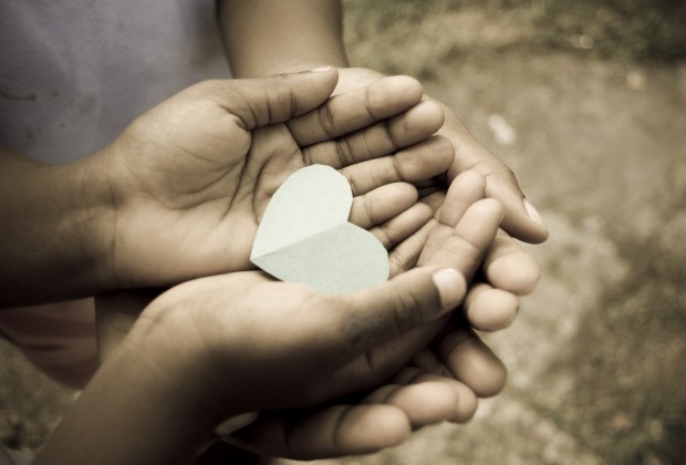 love; beautiful hands of children holding green heart shape