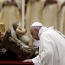 Pope Francis kisses a statue of Baby Jesus as he celebrates the Christmas Eve Mass in St. Peter's Basilica at the Vatican, Thursday, Dec. 24, 2015. (AP Photo/Gregorio Borgia)