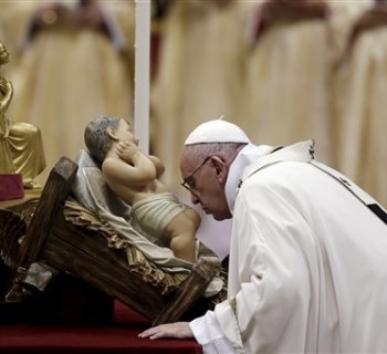 Pope Francis kisses a statue of Baby Jesus as he celebrates the Christmas Eve Mass in St. Peter's Basilica at the Vatican, Thursday, Dec. 24, 2015. (AP Photo/Gregorio Borgia)