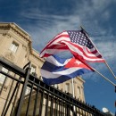 Edwardo Clark, a Cuban-American, holds an American flag and a Cuban flag as he celebrates outside the new Cuban embassy in Washington, Monday, July 20, 2015. The United States and Cuba restored full diplomatic relations Monday after more than five decades of frosty relations rooted in the Cold War. (AP Photo/Andrew Harnik)