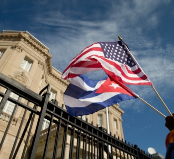 Edwardo Clark, a Cuban-American, holds an American flag and a Cuban flag as he celebrates outside the new Cuban embassy in Washington, Monday, July 20, 2015. The United States and Cuba restored full diplomatic relations Monday after more than five decades of frosty relations rooted in the Cold War. (AP Photo/Andrew Harnik)