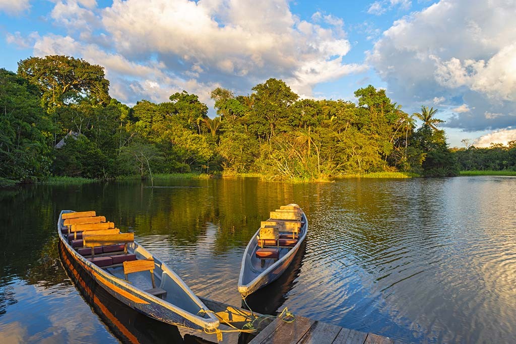 Two traditional wooden canoes at sunset in the Amazon River Basi