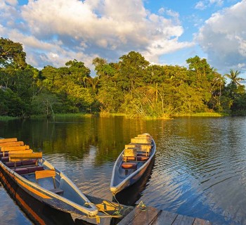 Two traditional wooden canoes at sunset in the Amazon River Basi