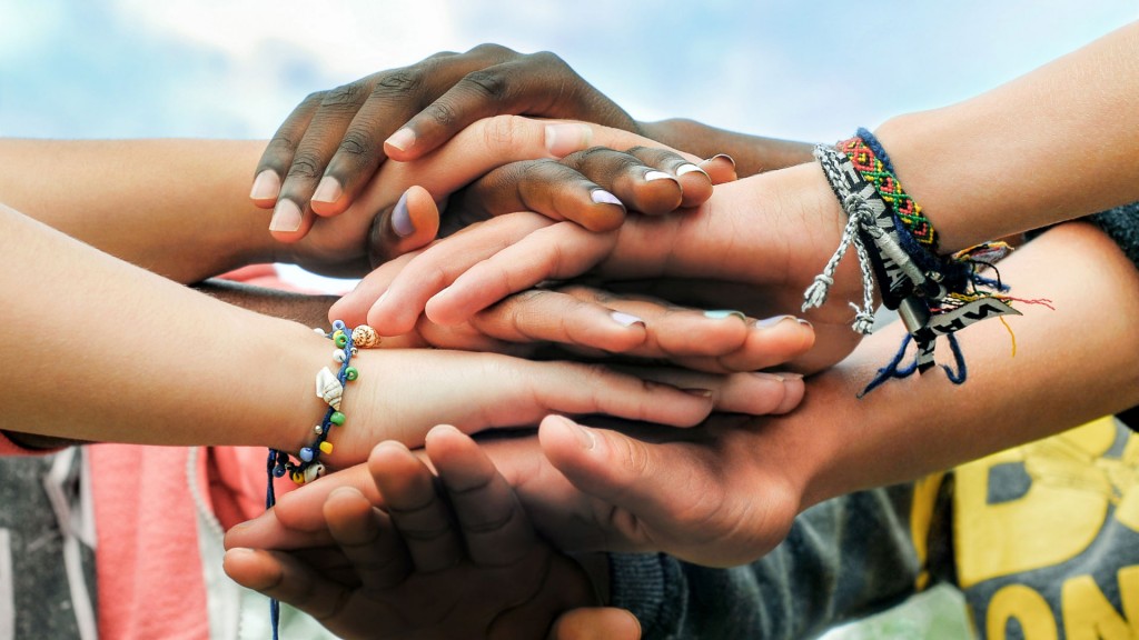 Adolescentes multirrraciais juntando as mãos em cooperação. (Foto: Shutterstock)