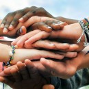 Adolescentes multirrraciais juntando as mãos em cooperação. (Foto: Shutterstock)