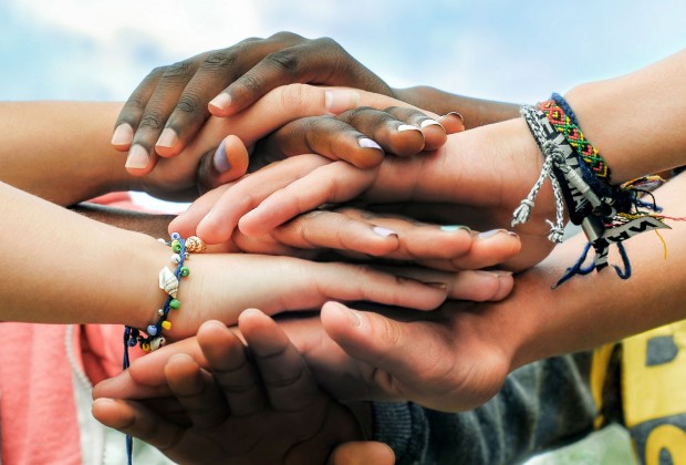 Adolescentes multirrraciais juntando as mãos em cooperação. (Foto: Shutterstock)