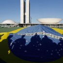 Demonstrators open a Brazil's flag in front of the National Congress during a protest in Brasilia, Brazil, Wednesday, June 26, 2013. The wave of protests that hit Brazil on June 17 began as opposition to transportation fare hikes, then expanded to a list of causes including anger at high taxes, poor services and high World Cup spending, before coalescing around the issue of rampant government corruption. (AP Photo/Eraldo Peres)