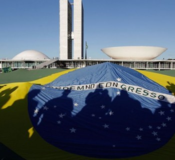 Demonstrators open a Brazil's flag in front of the National Congress during a protest in Brasilia, Brazil, Wednesday, June 26, 2013. The wave of protests that hit Brazil on June 17 began as opposition to transportation fare hikes, then expanded to a list of causes including anger at high taxes, poor services and high World Cup spending, before coalescing around the issue of rampant government corruption. (AP Photo/Eraldo Peres)
