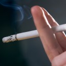Woman's fingers with smoking cigarette macro shot