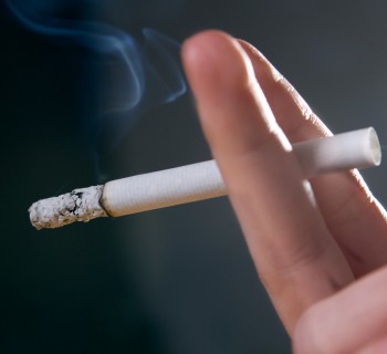 Woman's fingers with smoking cigarette macro shot