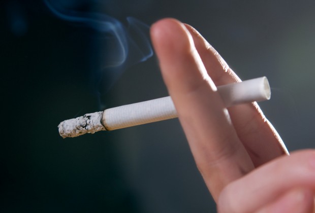 Woman's fingers with smoking cigarette macro shot