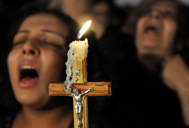 Coptic Christians carry a crucifix and chant prayers during a candlelight protest at Abassaiya Orthodox Cathedral in Cairo Oct. 16, one week after people were killed during clashes with soldiers and riot police. At least 26 people, mostly Christians, were killed Oct. 9 when troops broke up a peaceful protest against an earlier attack on a church in southern Egypt. (CNS photo/stringer via Reuters) (Oct. 18, 2011) See EGYPT-CHRISTIANS Oct. 10, 2011.