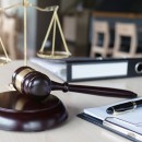 Close up of gavel and scales of justice and Report the case with paper on wooden table in office, Law and justice concept.