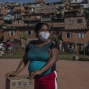 Moradora recebe uma cesta de alimentos e produtos de higiene doados na favela do Vale das Virtudes, São Paulo, 12 de junho de 2020. (Victor Moriyama/Bloomberg)