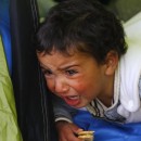 A migrant baby, waiting to cross the Greek-Macedonian border with family members, cries at a tent near the village of Idomeni, Greece March 8, 2016. REUTERS/Ognen Teofilovski