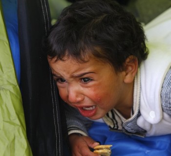 A migrant baby, waiting to cross the Greek-Macedonian border with family members, cries at a tent near the village of Idomeni, Greece March 8, 2016. REUTERS/Ognen Teofilovski