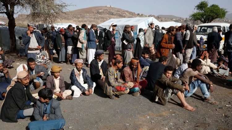 Refugiados esperando distribuição de alimento.