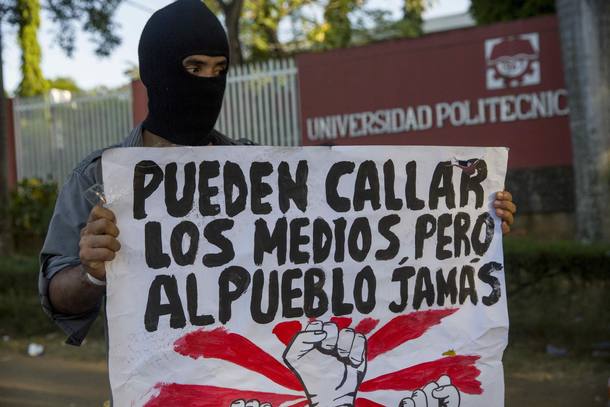 NI7014. MANAGUA (NICARAGUA), 22/04/2018.- Un joven con una cartel protesta frente a las instalaciones de la universidad politécnica de Nicaragua (Upoli) hoy, domingo 22 de abril de 2018, durante el quinto día de manifestaciones en contra de una reforma a la seguridad social, en Managua (Nicaragua). Las protestas en Nicaragua han dejado unos 27 muertos, según estadísticas de ONG, más de un centenar de heridos y daños a comercios. El gobierno nicaragüense derogó hoy las reformas que fueron las que causaron las violentas protestas en el país. EFE/Jorge Torres