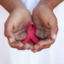 Child's hands holding an HIV awareness ribbon, Cape Town, South Africa