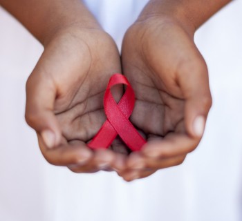 Child's hands holding an HIV awareness ribbon, Cape Town, South Africa