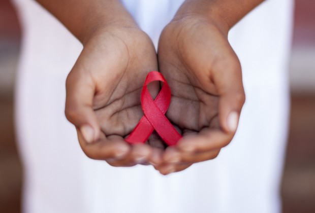 Child's hands holding an HIV awareness ribbon, Cape Town, South Africa