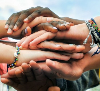 Adolescentes multirrraciais juntando as mãos em cooperação. (Foto: Shutterstock)