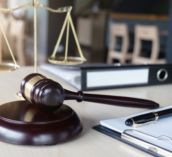 Close up of gavel and scales of justice and Report the case with paper on wooden table in office, Law and justice concept.