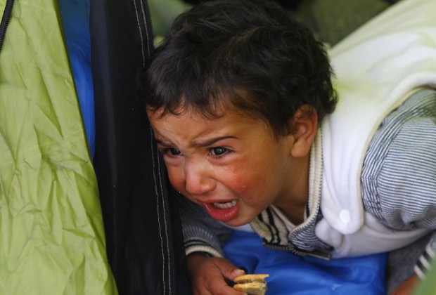 A migrant baby, waiting to cross the Greek-Macedonian border with family members, cries at a tent near the village of Idomeni, Greece March 8, 2016. REUTERS/Ognen Teofilovski